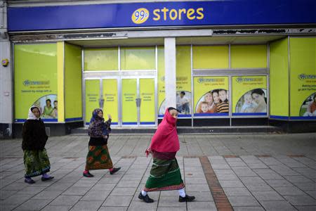 Nepalese women walk past a 99 pence discount shop on the edge of the town centre in Aldershot in southern England October 29, 2013. REUTERS/Dylan Martinez