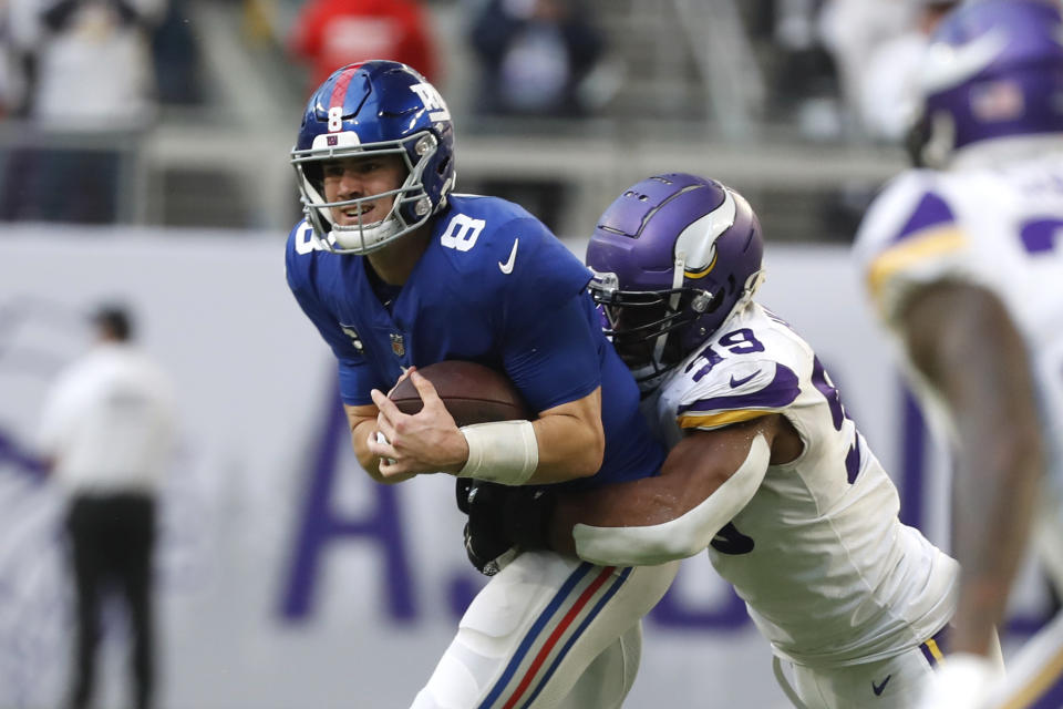 New York Giants quarterback Daniel Jones (8) tries to break a tackle by Minnesota Vikings linebacker Danielle Hunter (99) during the second half of an NFL football game, Saturday, Dec. 24, 2022, in Minneapolis. (AP Photo/Bruce Kluckhohn)