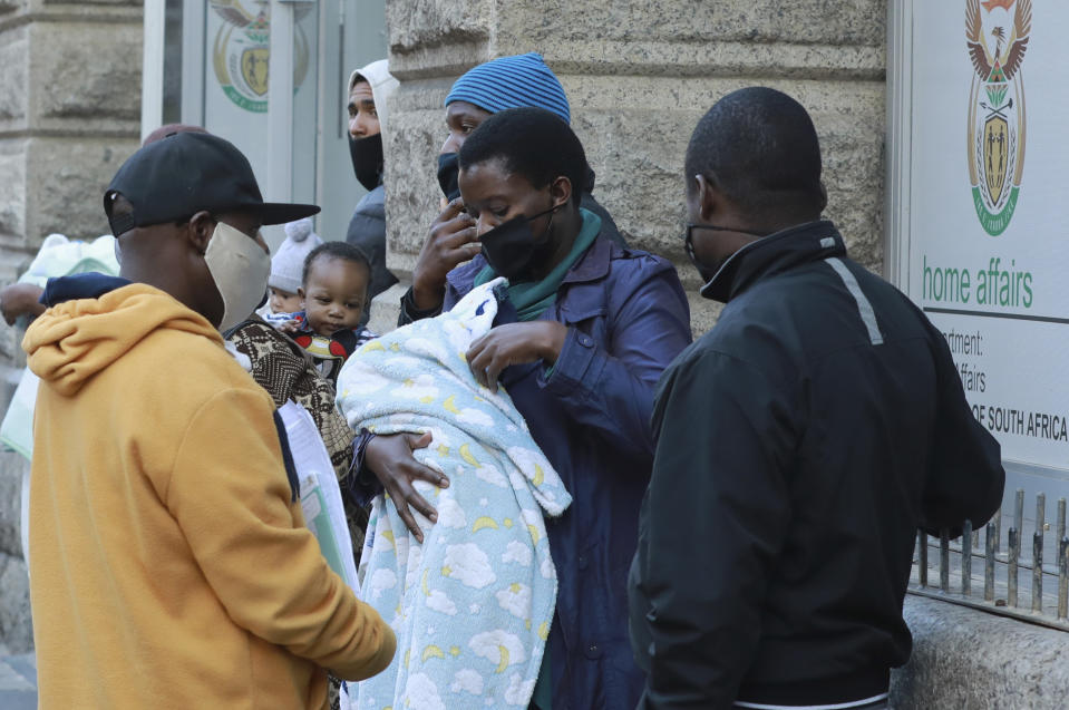 Parents wearing protective masks wait to register their newly-born child at the Home Affairs offices in Cape Town, South Africa, Wednesday June 17, 2020. The country now has more than a quarter of the coronavirus cases on the 54-nation African continent with more than 73,000 cases after new, record-high infections were registered in South Africa over the weekend. (AP Photo/Nardus Engelbrecht)