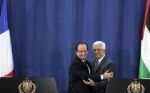 Palestinian President Mahmoud Abbas (R) and his French counterpart Francois Hollande embrace during a joint news conference in the West Bank city of Ramallah November 18, 2013. REUTERS/Ammar Awad