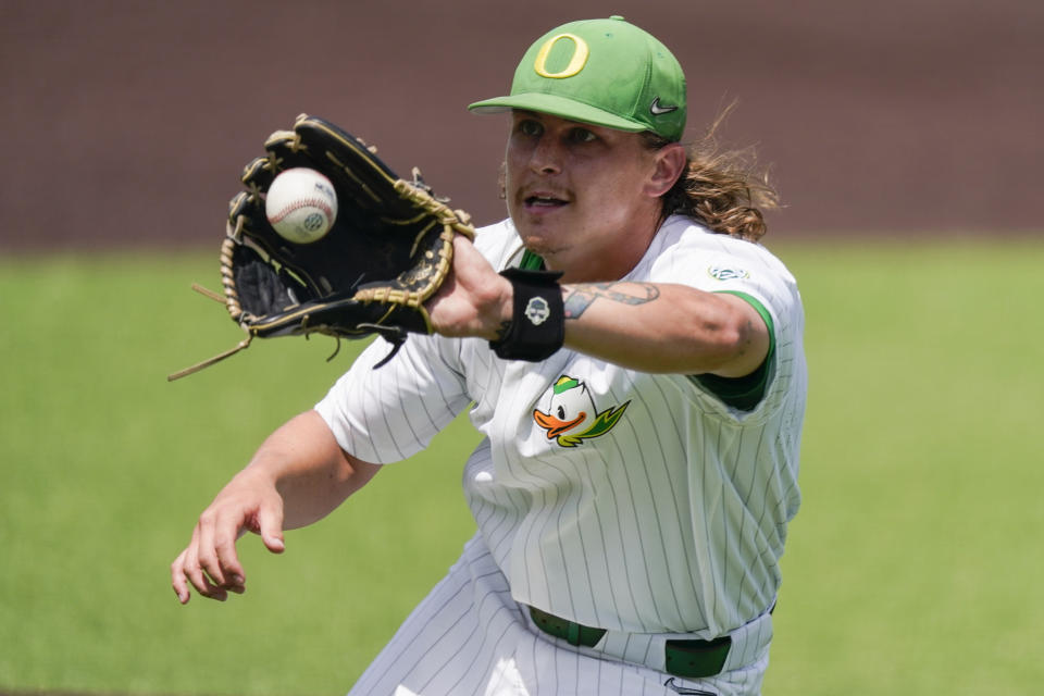 Oregon pitcher Matt Dallas fields a ground ball during the eighth inning of an NCAA college baseball tournament regional game against Xavier Friday, June 2, 2023, in Nashville, Tenn. Oregon won 5-4. (AP Photo/George Walker IV)