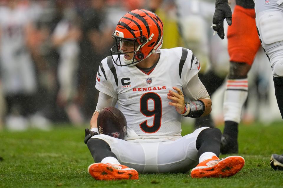 Cincinnati Bengals quarterback Joe Burrow recovers on the ground after being sacked by Cleveland Browns defensive end Myles Garrett.