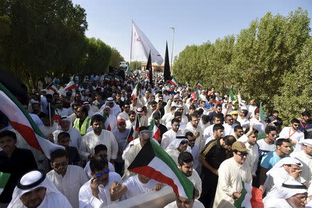 Mourners hold flags as the bodies of victims of Friday's bombing are buried in Al Jafariya cemetery in Suleibikhat, Kuwait June 27, 2015. REUTERS/Jassim Mohammed