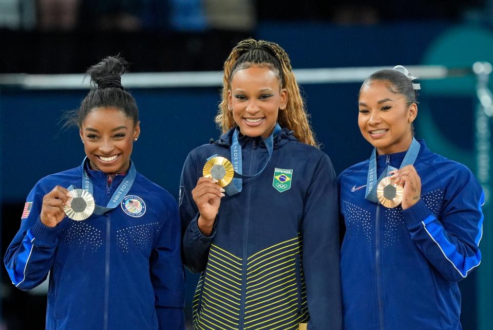 Aug 5, 2024; Paris, France; Simone Biles of the United States, Rebeca Andrade of Brazil, and Jordan Chiles of the United States with their medals on the floor exercise on day three of the gymnastics event finals during the Paris 2024 Olympic Summer Games.