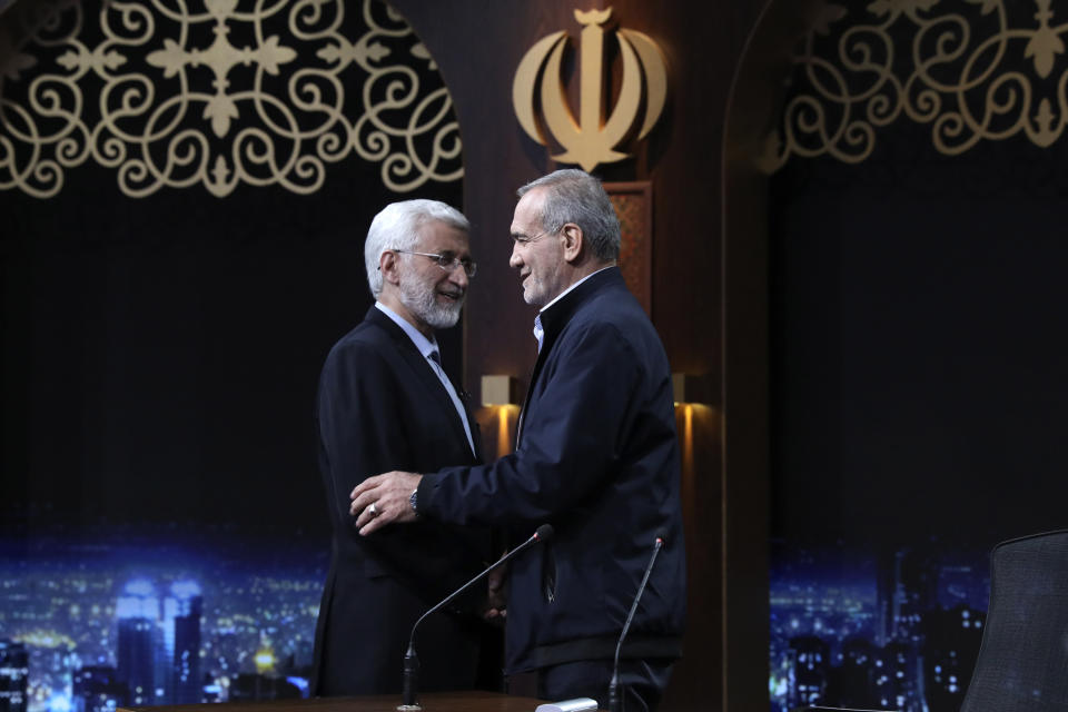 In this photo made available by Iranian state-run TV, IRIB, Iranian presidential candidate Saeed Jalili, left, a hard-line former nuclear negotiator, and reformist candidate Masoud Pezeshkian greet one another at the conclusion of a debate at the TV studio in Tehran, Iran, Monday, June 1, 2024. (Morteza Fakhri Nezhad/IRIB via AP)