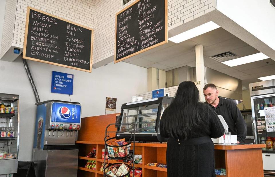 Kinley Gee, right, helps a customer at the counter at Downtown Oak, a coffee and sandwich shop that recently opened in the Hotel Virginia Building in downtown Fresno.