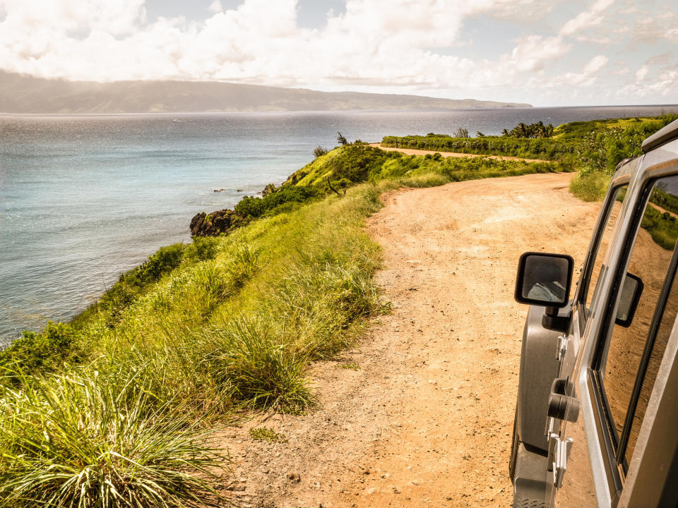 4x4 vehicle driving along a coast road.