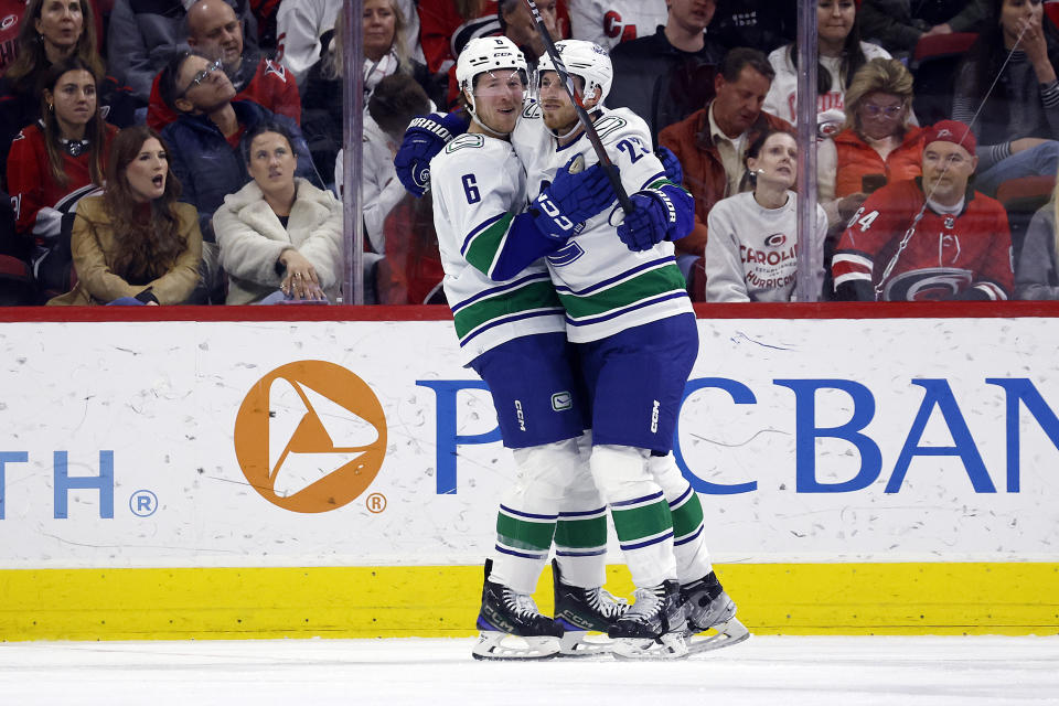 Vancouver Canucks Elias Lindholm, right, celebrates his second goal against the Carolina Hurricanes with Brock Boeser (6), during the second period of an NHL hockey game in Raleigh, N.C., Tuesday, Feb. 6, 2024. (AP Photo/Karl B DeBlaker)