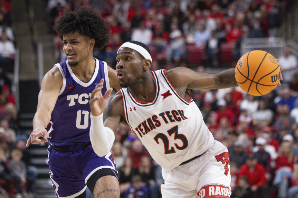 Texas Tech De'Vion Harmon (23) dribbles past TCU Micah Peavy (0) during the first half of an NCAA college basketball game, Saturday, Feb. 25, 2023, in Lubbock, Texas. (AP Photo/Chase Seabolt)