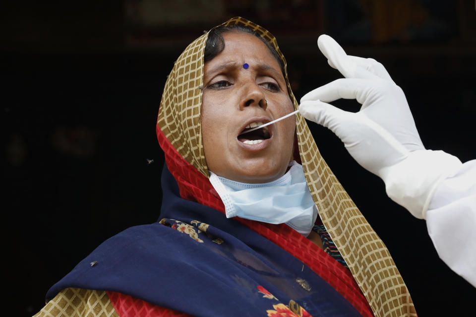 A health worker takes a swab sample of a woman to test for COVID-19 in Kusehta village north of Prayagraj, India, Saturday, May 29, 2021. (AP Photo/Rajesh Kumar Singh)