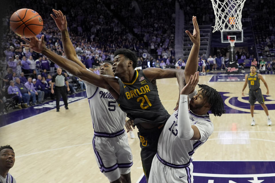Baylor center Yves Missi (21) beats Kansas State guard Cam Carter (5) to a rebound during the first half of an NCAA college basketball game Tuesday, Jan. 16, 2024, in Manhattan, Kan. (AP Photo/Charlie Riedel)