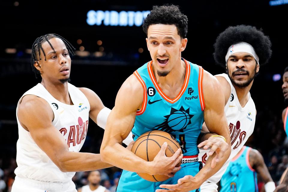 Phoenix Suns' Landry Shamet, center, is double-teamed by Cleveland Cavaliers' Isaac Okoro, left, and Jarrett Allen, right, during the first half of an NBA basketball game in Phoenix, Sunday, Jan. 8, 2023.