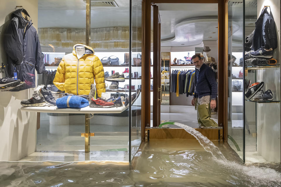 A shopkeeper checks the operation of his electric pump as he clears out the building (Getty)