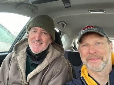 During the Dec. 23 rain storm on Cape Cod, friends Louie Kerr (left) and Eric Jensen put their heads together to figure out the location of a message in the bottle and a $500 reward. The Cape-wide treasure hunt was sponsored by Whydah Pirate Museum in West Yarmouth and The Brewster Boys.