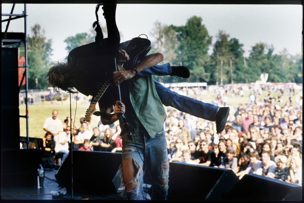 Climbing to ascendancy (while the Seattle city and police were stomping on the Black music scene). Kurt Cobain and Krist Novoselic skylarking with Nirvana, 1991. (Credit: Gie Knaeps via Getty Images)