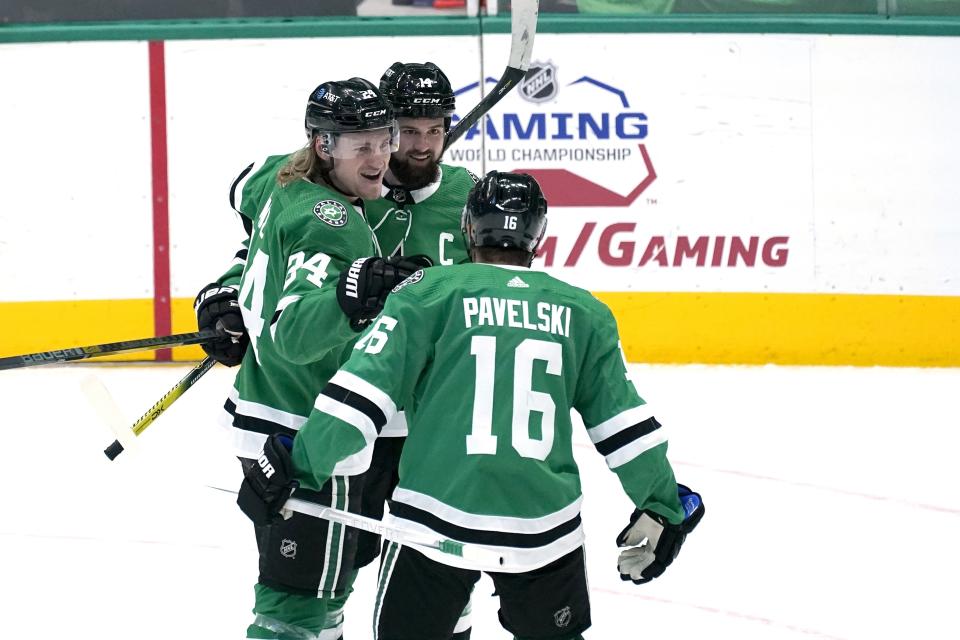 Dallas Stars' Joe Pavelski (16), Roope Hintz (24) and Jamie Benn, rear, celebrate a goal scored by Benn in the first period of an NHL hockey game against the Florida Panthers in Dallas, Saturday, April 10, 2021. Pavelski was credited with the assist on the goal. (AP Photo/Tony Gutierrez)