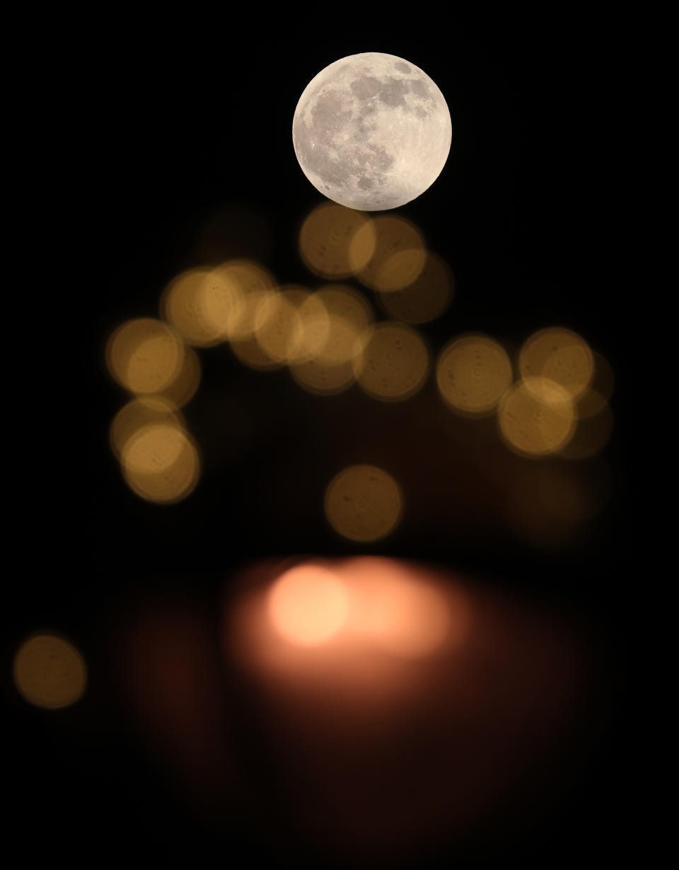 The wolf moon, the first full moon of 2020, juxtaposed with street lights in London.