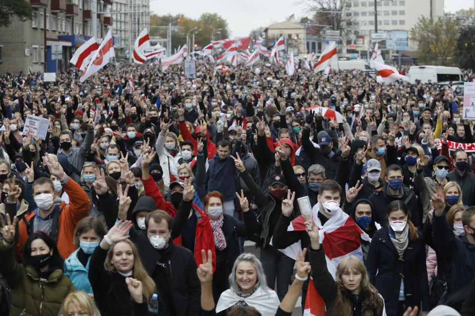 People with old Belarusian national flags march during an opposition rally to protest the official presidential election results in Minsk, Belarus, Sunday, Oct. 25, 2020. The demonstrations were triggered by official results giving President Alexander Lukashenko 80% of the vote in the Aug. 9 election that the opposition insists was rigged. Lukashenko, who has ruled Belarus with an iron fist since 1994, has accused the United States and its allies of fomenting unrest in the ex-Soviet country. (AP Photo)