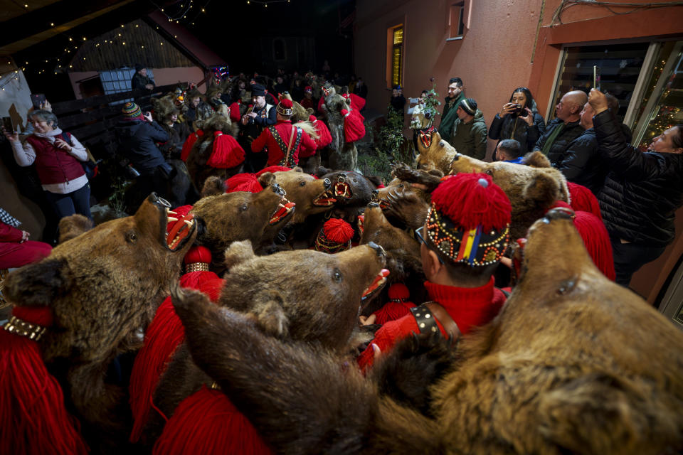 Integrantes del grupo Sipoteni realizan una danza ritual en una casa en Brusturoasa, en el norte de Rumanía, el 26 de diciembre de 2023. Hace siglos, quienes vivían en lo que ahora es el noreste de Rumanía se cubrían con pieles de oso y bailaban para ahuyentar a los malos espíritus. Esa costumbre es conocida hoy en día como el Festival del Baile del Oso, que cada diciembre atrae a multitud de turistas. (AP Foto/Vadim Ghirda)