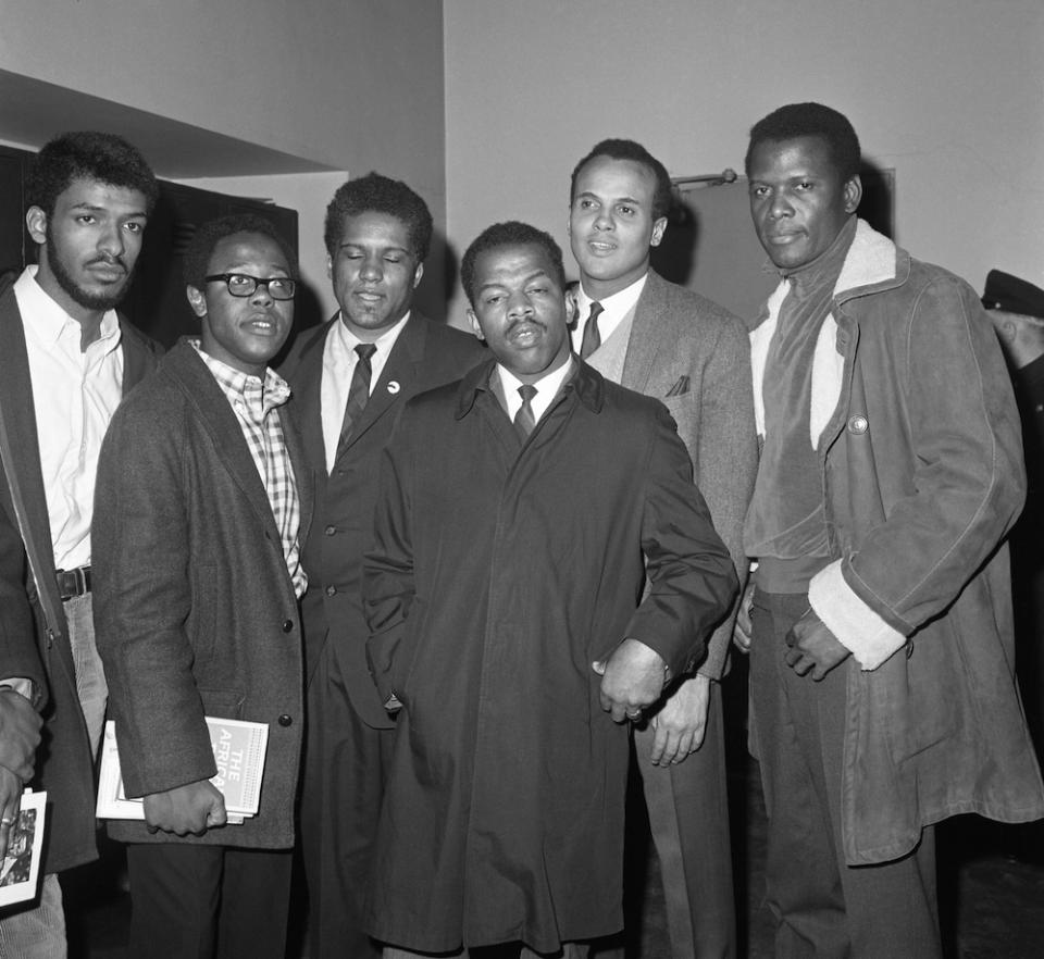 Actor Sidney Poitier (R) and singer/actor Harry Belafonte (2nd from R) leave Criminal Courts building after poising $50 bond each for James Forman (L) and John Lewis. Forman, Lewis, and three others were charged with disorderly conduct and trespassing after refusing to leave the South African Consulate.