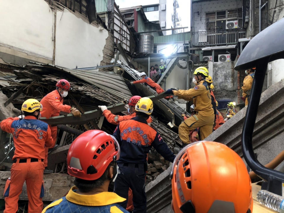 台中市中區台灣大道一段1棟2層樓房屋30日倒塌，壓住旁邊施工的3人，蔡姓男子救出送醫不治，另2人待援。消防人員只能徒手持續搶救受困工人。（台中市政府提供）