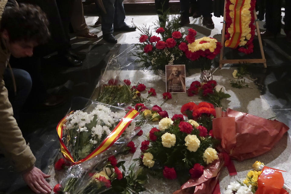 In this photo taken on Tuesday, Nov. 20, 2018, flowers are placed on the tomb of former Spanish dictator Francisco Franco inside the basilica at the the Valley of the Fallen monument near El Escorial, outside Madrid. After a tortuous judicial and public relations battle, Spain's Socialist government has announced that Gen. Francisco Franco's embalmed body will be relocated from a controversial shrine to a small public cemetery where the former dictator's remains will lie along his deceased wife. (AP Photo/Manu Fernandez)
