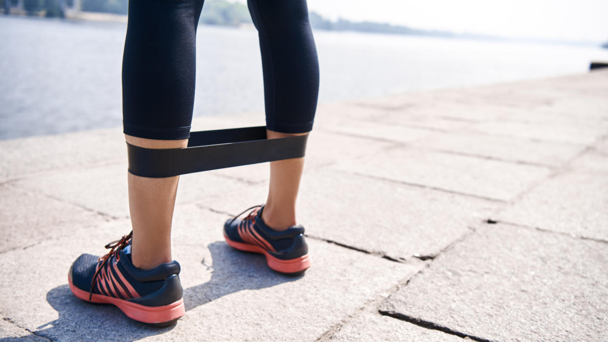  Close up of resistance band around runner's legs. 