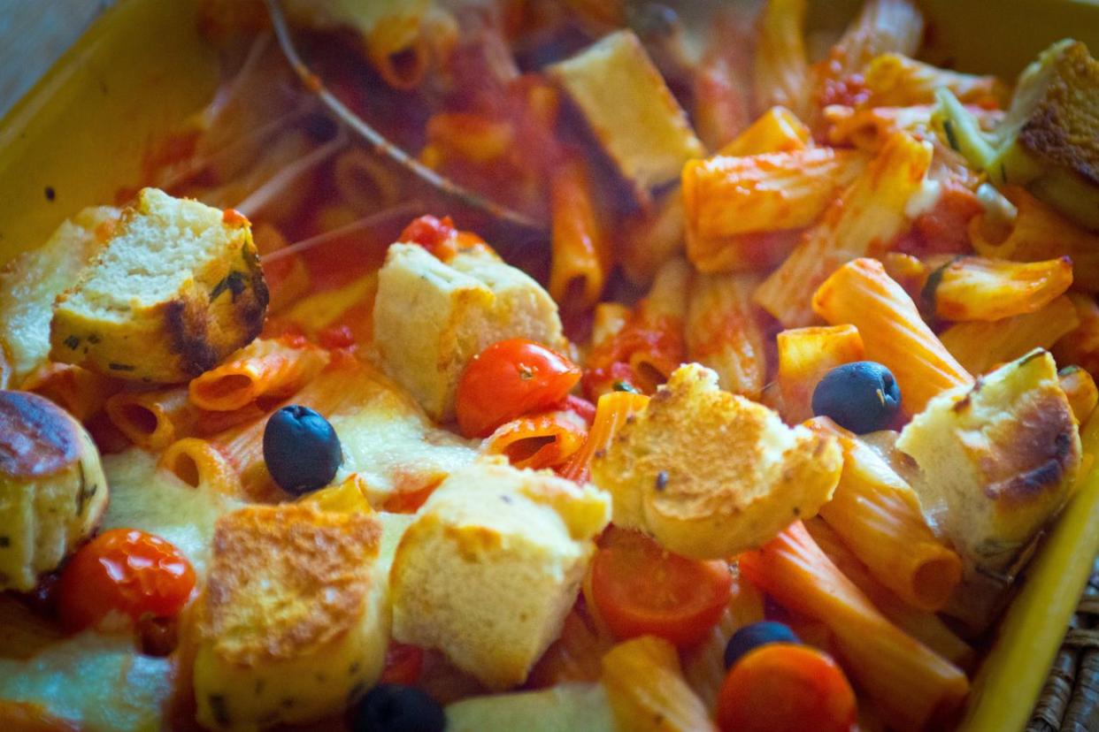 Crouton tomato casserole with pasta, cherry tomatoes and black whole olives