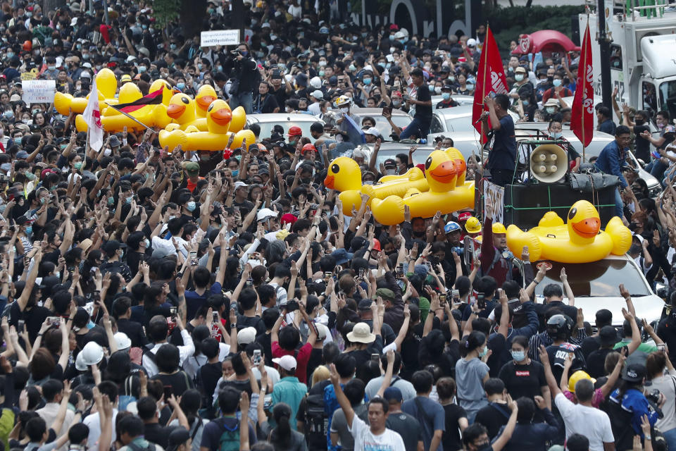 Large inflatable ducks are passed around the crowd at a pro-democracy rally in Bangkok, Thailand, Wednesday, Nov. 18, 2020. Police in Thailand's capital braced for possible trouble Wednesday, a day after a protest outside Parliament by pro-democracy demonstrators was marred by violence that left dozens of people injured. (AP Photo/Sakchai Lalit)
