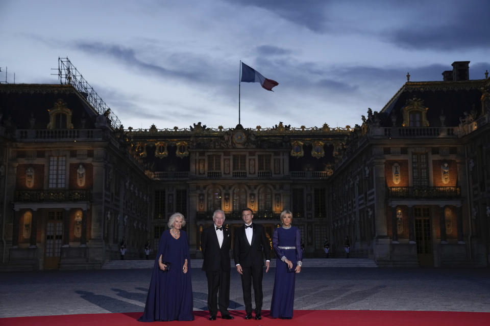 FILE - French President Emmanuel Macron, center right, his wife Brigitte Macron, right, Britain's King Charles III, center left, and Queen Camilla arrive for a state dinner, at the Chateau de Versailles, west of Paris, Wednesday, Sept. 20, 2023. At an age when many of his contemporaries have long since retired, King Charles III is not one to put his feet up. The king will mark his 75th birthday on Tuesday, Nov. 14, 2023, by highlighting causes close to his heart. With Queen Camilla at his side, Charles will visit a project that helps feed those in need by redistributing food that might otherwise go to landfills. (AP Photo/Christophe Ena)