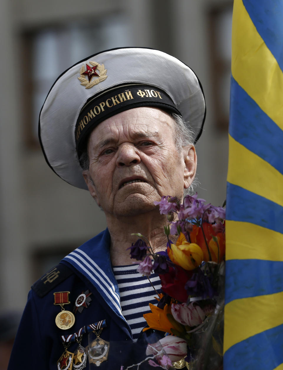 A World War II veteran attends a Victory Day celebration, which commemorates the 1945 defeat of Nazi Germany, in the center of Slovyansk, eastern Ukraine, Friday, May 9, 2014. Putin's surprise call on Wednesday for delaying the referendum in eastern Ukraine appeared to reflect Russia's desire to distance itself from the separatists as it bargains with the West over a settlement to the Ukrainian crisis. But insurgents in the Russian-speaking east defied Putin's call and said they would go ahead with the referendum. (AP Photo/Darko Vojinovic)