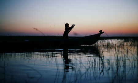 An Iraqi Marsh Arab girl paddles her boat at the Chebayesh marsh in Dhi Qar province, Iraq April 13, 2019. Picture taken April 13, 2019. REUTERS/Thaier al-Sudani