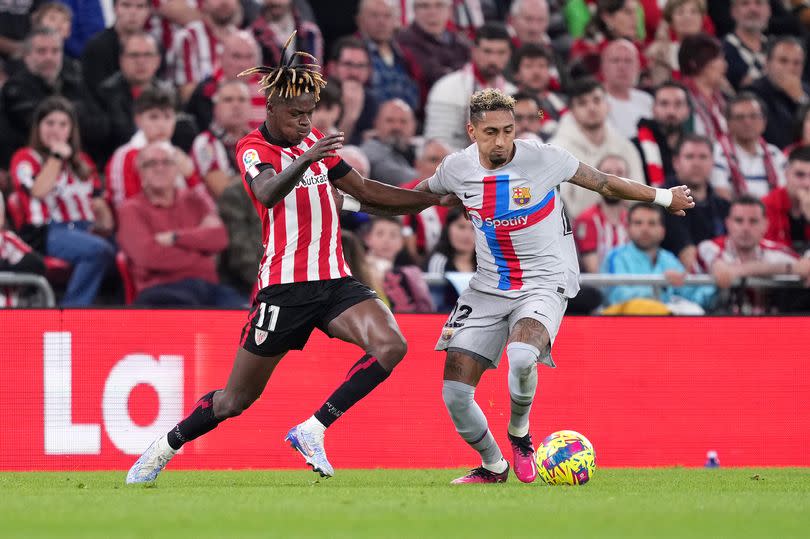 Raphinha of FC Barcelona is challenged by Nico Williams of Athletic Club during the LaLiga Santander match between Athletic Club and FC Barcelona at San Mames Stadium on March 12, 2023 in Bilbao, Spain.