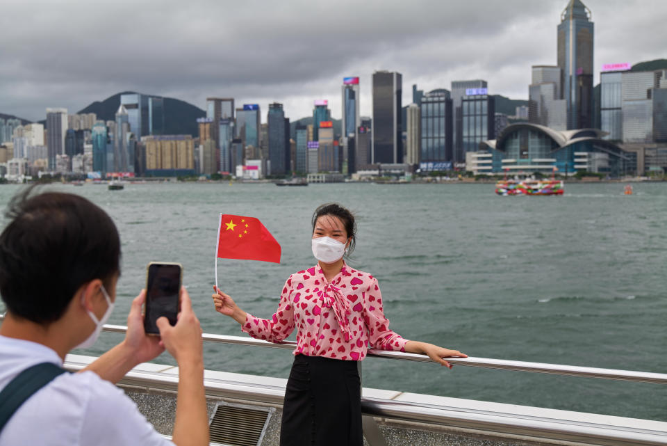 HONG KONG, CHINA - 2022/07/01: A woman poses for a photo in front of Hong Kong Bay during the anniversary ceremony. Hong Kong celebrates with great fanfare the 25th anniversary of the return of Hong Kong to Chinese rule in the presence of the Chinese president. (Photo by Emmanuel Serna/SOPA Images/LightRocket via Getty Images)