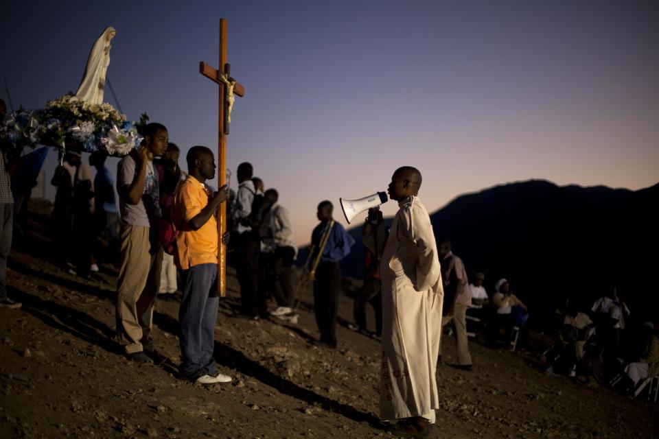 In this Feb. 9, 2014 photo, Rev. Jules Campion leads a procession of Christian pilgrims carrying a statue of Our Lady of Fatima in the village of Bois-Neuf, Haiti. Christian pilgrims came to the barren mountainside in central Haiti seeking favors and spiritual renewal. (AP Photo/Dieu Nalio Chery)