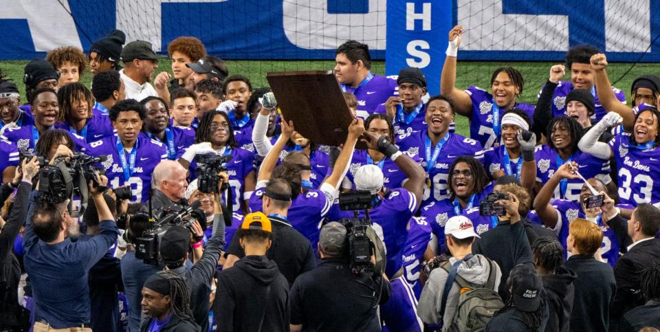 Ben Davis High School players celebrate with the trophy after winning an IHSAA Class 6A State Championship football game against Crown Point High School, Saturday, Nov. 25, 2023, at Lucas Oil Stadium, in Indianapolis. Ben Davis High School won, 38-10.