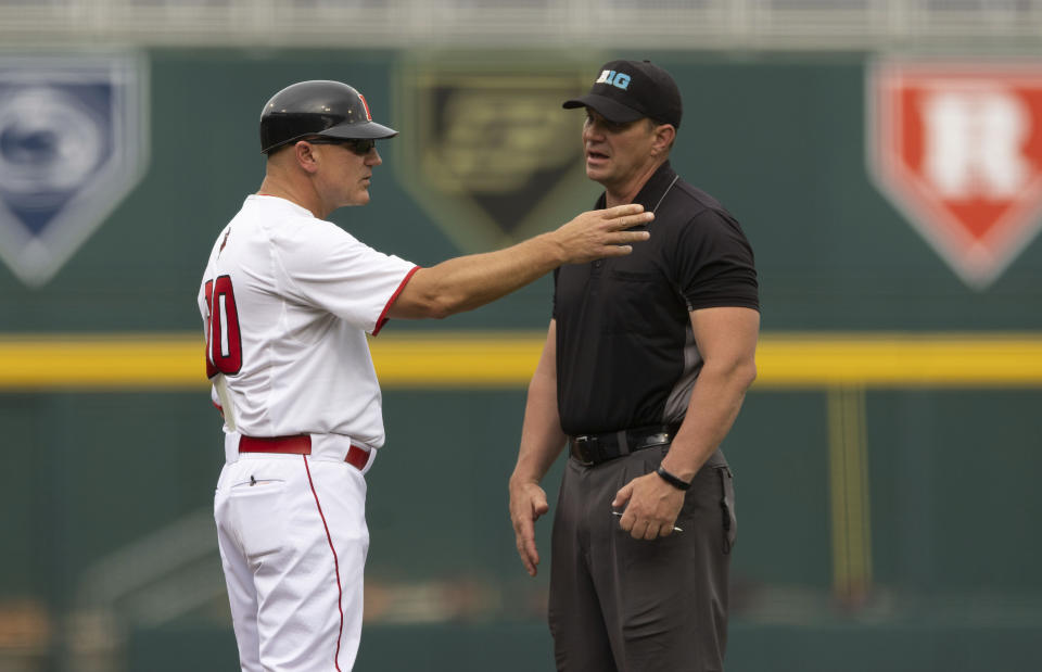 Rutgers head coach Steve Owens, left, talks with an umpire as they review a play against Michigan in the first inning of the NCAA college Big Ten baseball championship game Sunday, May 29, 2022, at Charles Schwalb Field in Omaha, Neb. (AP Photo/Rebecca S. Gratz)