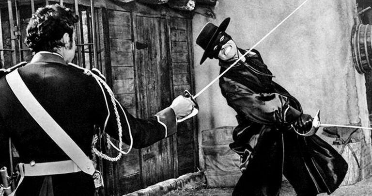 Guy Williams, en una escena clásica del Zorro más querido por los argentinos. De espaldas, Britt Lomond (el capitán Monasterio)