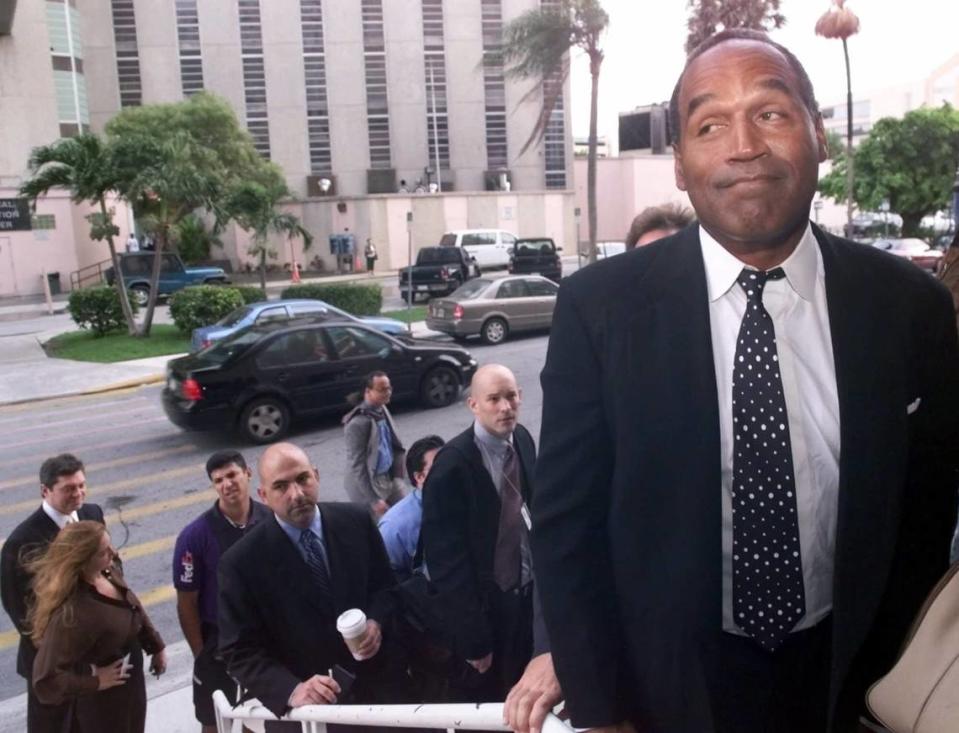 O.J. Simpson espera en la fila para entrar en el tribunal de circuito de Miami, el 9 de octubre de 2001, en Miami, para la fase de selección del jurado de su juicio por un delito grave de robo de automóvil y un delito menor de lesiones, derivados de un encuentro airado con otro automovilista en su barrio de los suburbios de Miami. Simpson fue acusado de arañar la cara del conductor mientras le quitaba las gafas.