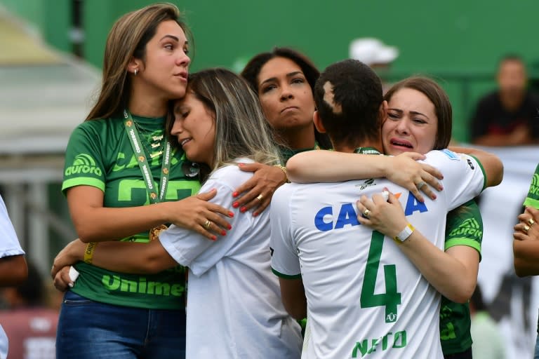 Brazilian Chapecoense footballer Helio Neto (front-R), a survivor of the LaMia airplane crash in Colombia, embraces relatives of players who died at the Arena Conda stadium on January 21, 2017