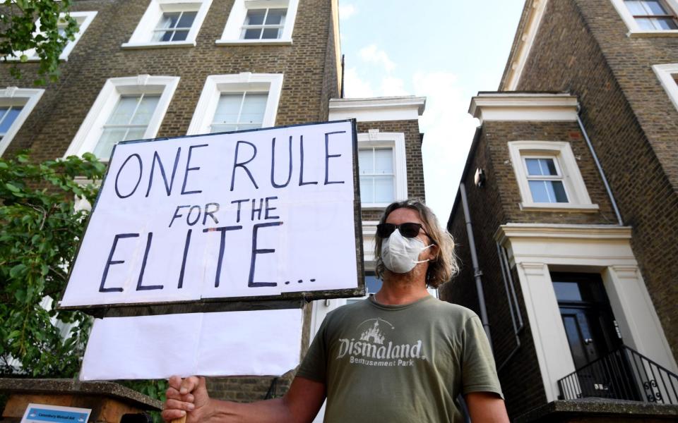A protester outside Dominic Cummings' home in London - Shutterstock