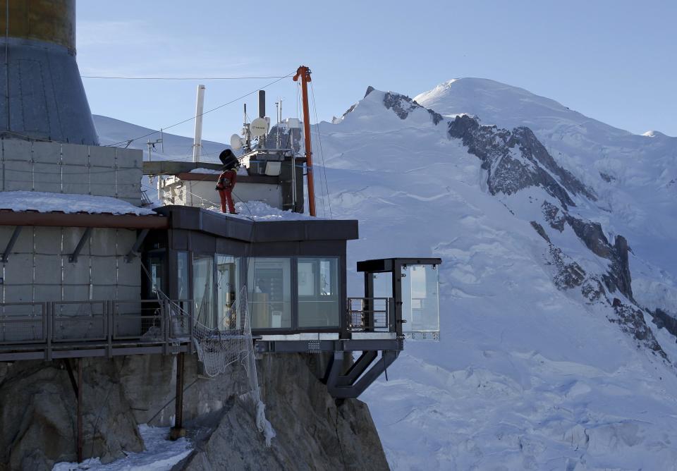 View of the 'Step into the Void' installation at the Aiguille du Midi mountain peak above Chamonix, in the French Alps, December 17, 2013. The Chamonix Skywalk is a five-sided glass structure installed on the top terrace of the Aiguille du Midi (3842m), with a 1,000 metre drop below, where visitors can step out from the terrace, giving the visitors the impression of standing in the void. The glass room will open to the public on December 21, 2013. At R, the Mont-Blanc mountain. REUTERS/Robert Pratta (FRANCE - Tags: SOCIETY TRAVEL CITYSCAPE)