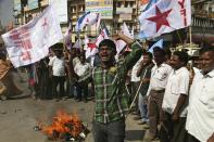 Left party activists shout slogans after burning an effigy of the U.S. to protest against the alleged mistreatment of New York based Indian diplomat Devyani Khobragade, in Hyderabad, India, Wednesday, Dec. 18, 2013. The Indian diplomat said she faced repeated "handcuffing, stripping and cavity searches" following her arrest in New York City on visa fraud charges in a case that has infuriated the government in New Delhi. (AP Photo/Mahesh Kumar A.)