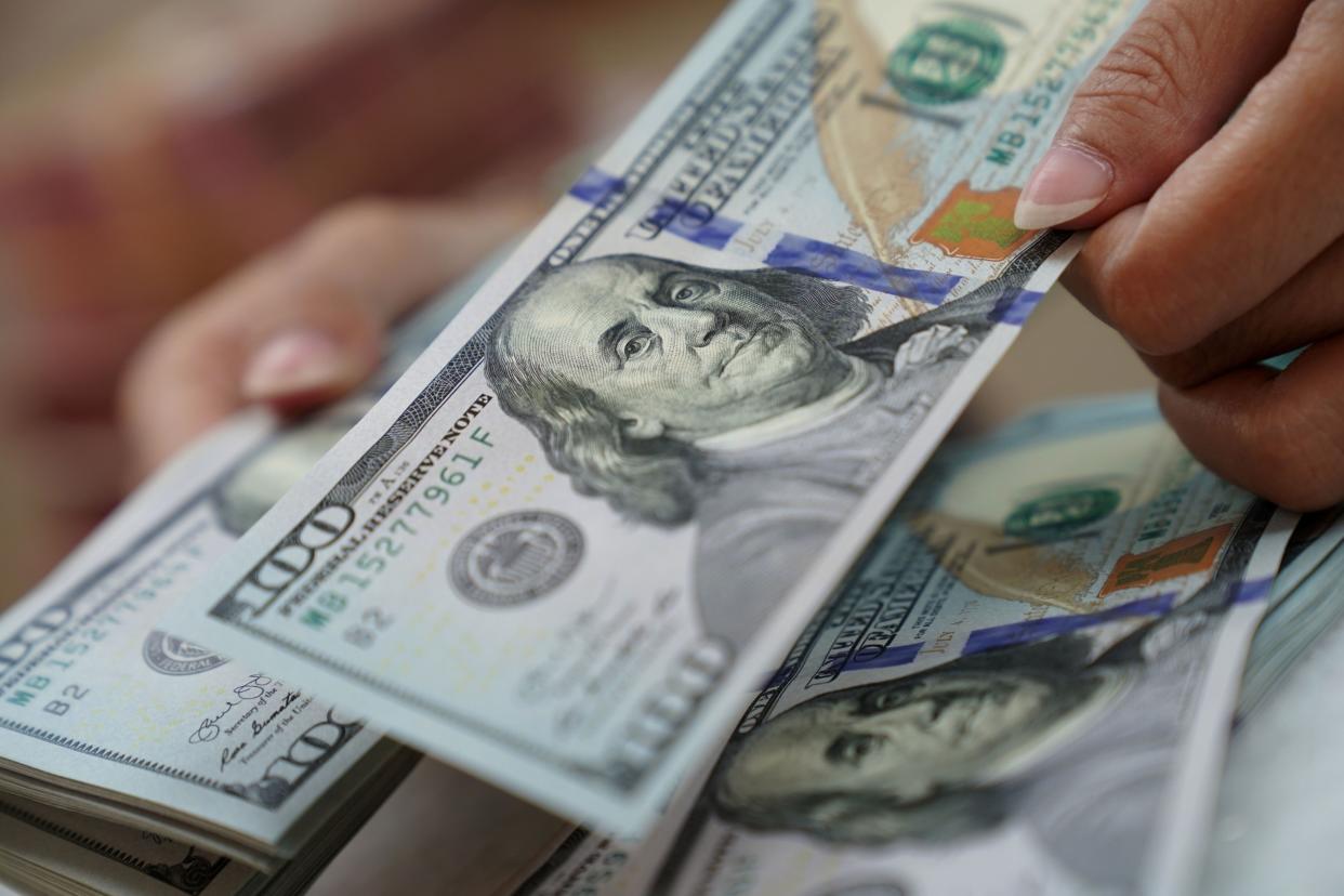 A worker counts U.S. dollar banknotes at a currency exchange office in Jakarta, Indonesia, on Wednesday, March 2, 2022. (Dimas Ardian/Bloomberg)