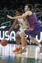 Clemson guard Alex Hemenway (12) defends Miami guard Charlie Moore (3) during the first half of an NCAA college basketball game, Saturday, Dec. 4, 2021, in Coral Gables, Fla. (AP Photo/Marta Lavandier)