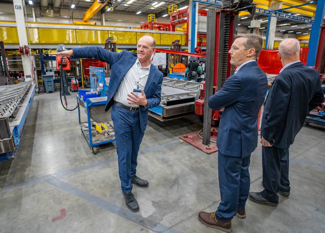 Michael Cahill, left, president of Siemens Mobility North America Rolling Stock, shows Amtrak President Roger Harris, middle, and other visitors around the Siemens Mobility manufacturing facility in Sacramento on Wednesday, Oct. 11, 2023.