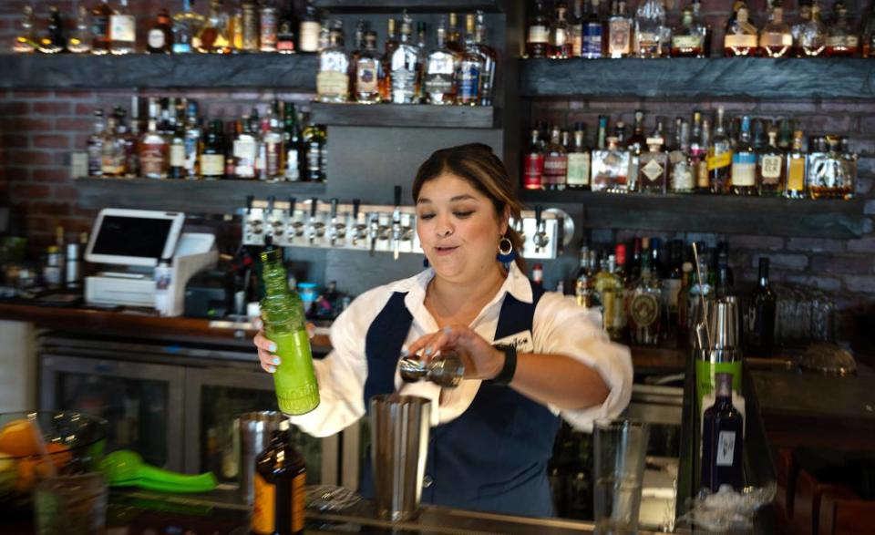 La camarera Mónica Reynoso prepara un coctel en el restaurante Cora de Roseburg Square en Modesto, California, el viernes 24 de mayo de 2024.