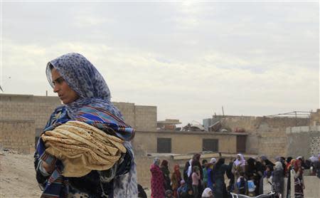 A woman holds bread in Minbij city in the east countryside of Aleppo in this October 18, 2013 file photo. REUTERS/Aref Hretani/Files