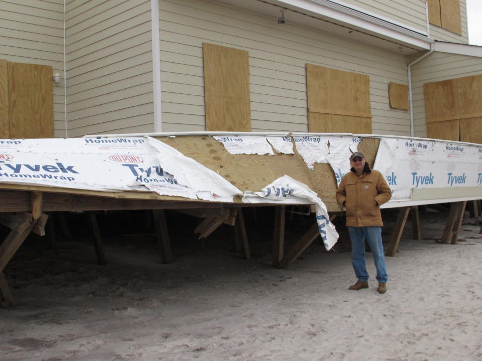 In this Friday, Nov. 16, 2012 photo, homeowner Hyman Portnoy stands outside the damaged deck of his home in Ocean Beach, N.Y. The home was among hundreds destroyed or damaged on Fire Island during Superstorm Sandy. (AP Photo/Frank Eltman)