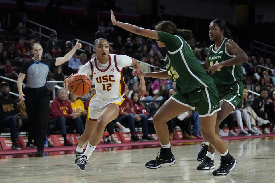 Southern California guard JuJu Watkins (12) controls the ball against Le Moyne guard Leah Middleton (25) and forward Brianna Williams (44) during the second half of an NCAA college basketball game in Los Angeles, Monday, Nov. 13, 2023. (AP Photo/Ashley Landis)